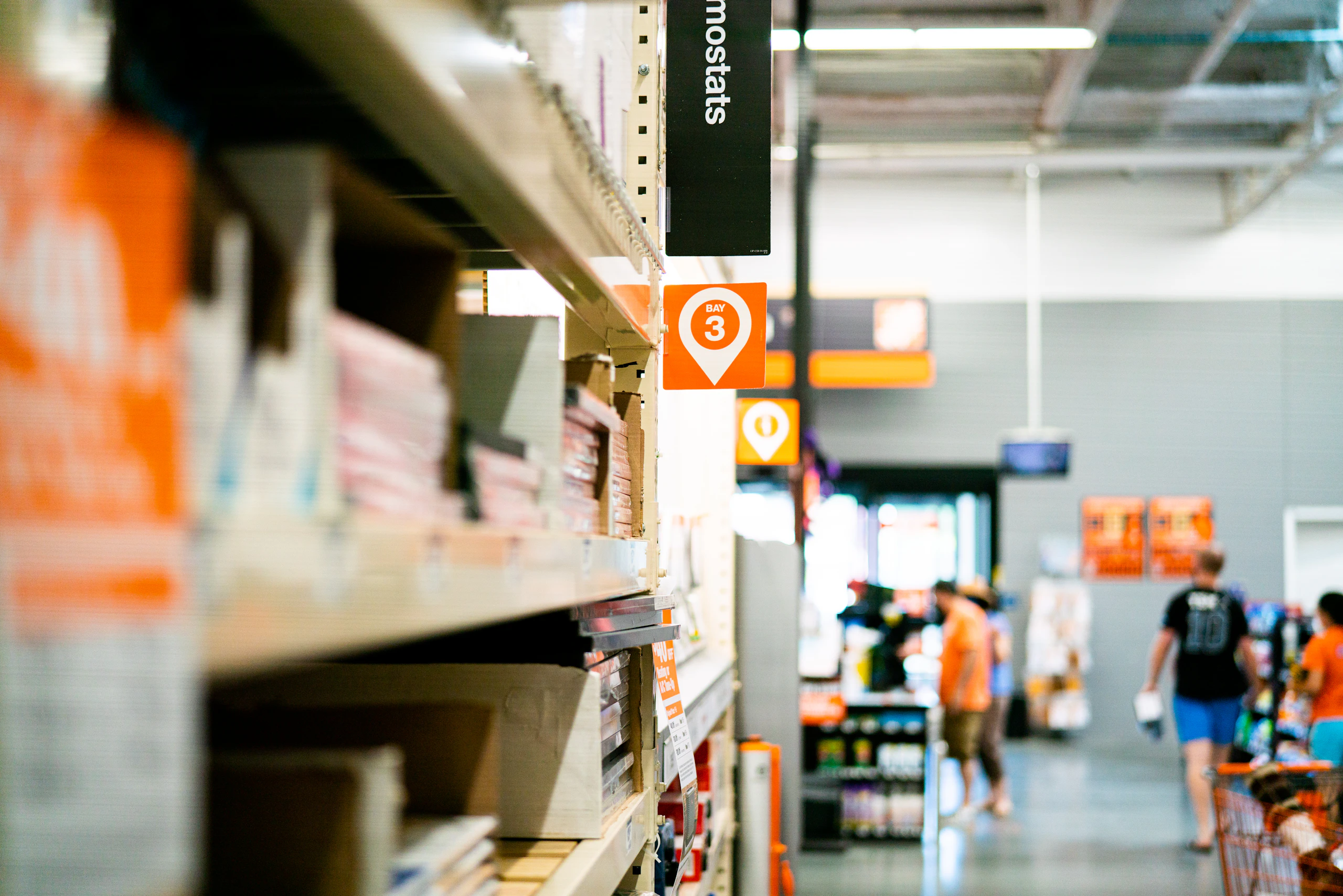 A retail aisle with bay signage receding into the store